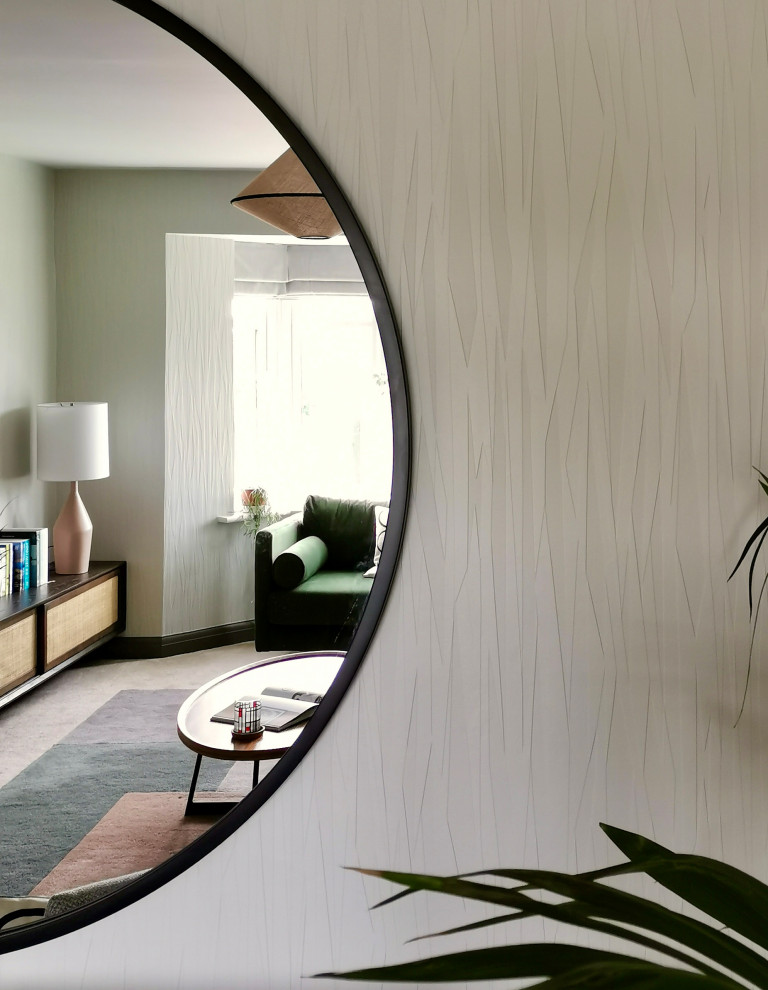 На фото: изолированная гостиная комната среднего размера в скандинавском стиле с серыми стенами, ковровым покрытием, телевизором на стене, бежевым полом и обоями на стенах без камина