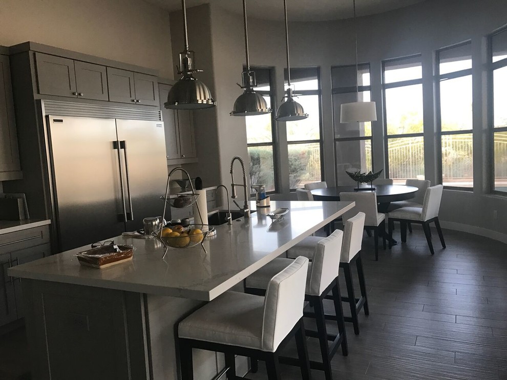 Open concept kitchen - mid-sized rustic l-shaped porcelain tile and gray floor open concept kitchen idea in Phoenix with an undermount sink, shaker cabinets, gray cabinets, quartzite countertops, white backsplash, glass tile backsplash, stainless steel appliances and an island
