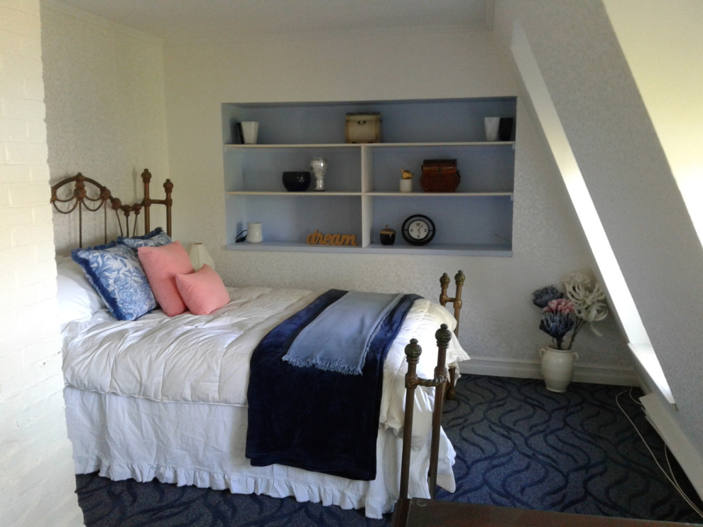 Large beach style master bedroom in Other with white walls, carpet and blue floor.