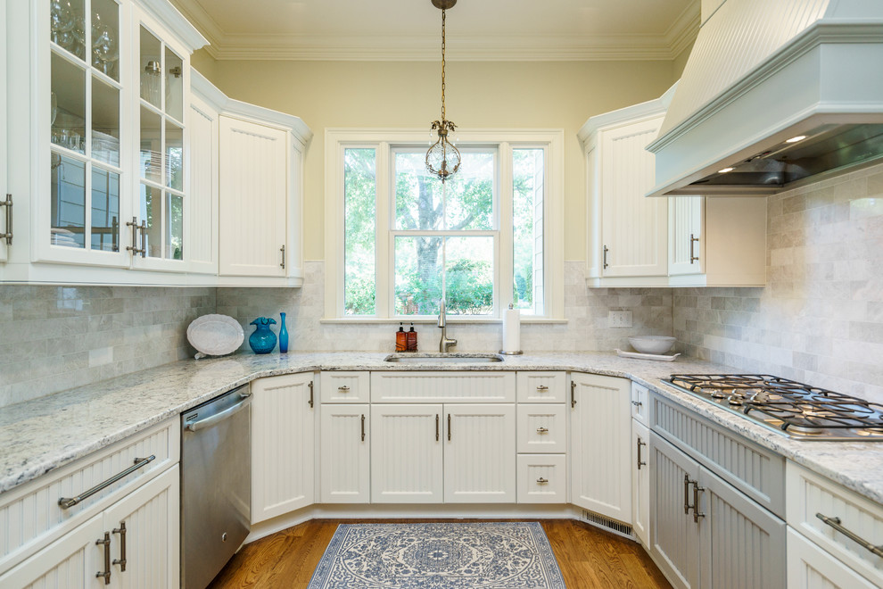Design ideas for a transitional kitchen in Raleigh with white cabinets, granite benchtops, white splashback, marble splashback, stainless steel appliances, light hardwood floors and with island.