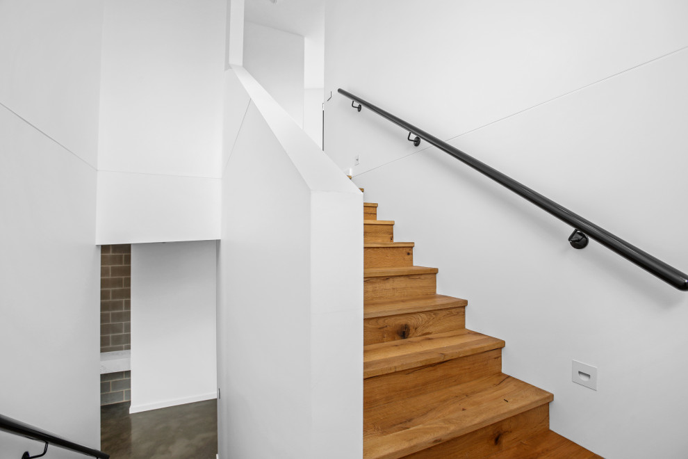 Inspiration for a large modern wood u-shaped staircase in Other with wood risers and metal railing.