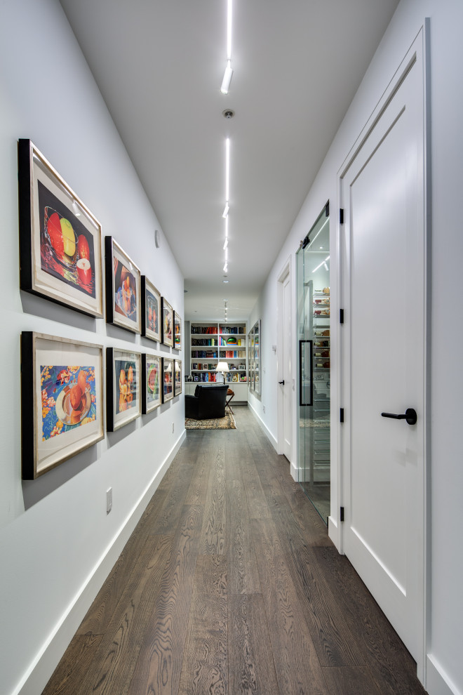 Design ideas for a mid-sized modern hallway in Vancouver with white walls, dark hardwood floors and brown floor.