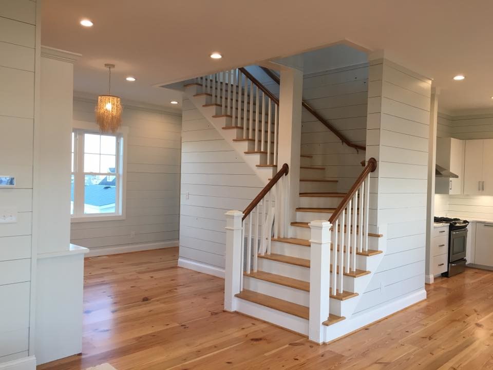 Photo of a beach style wood l-shaped staircase in Other with wood risers and wood railing.
