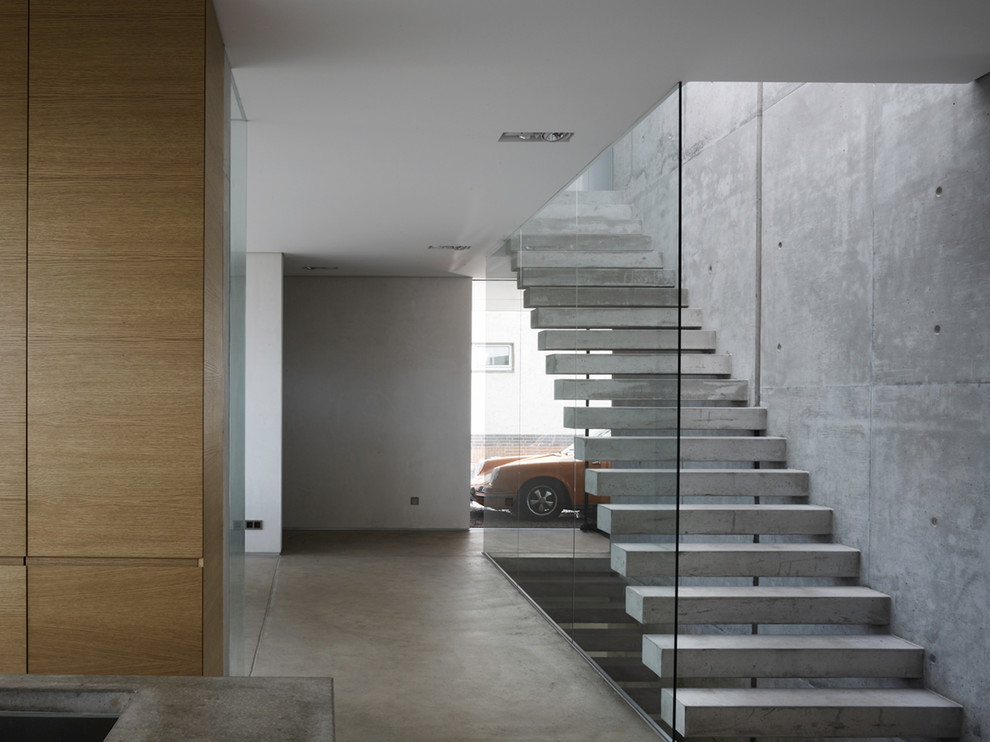 Photo of a large contemporary concrete straight staircase in Other with open risers.