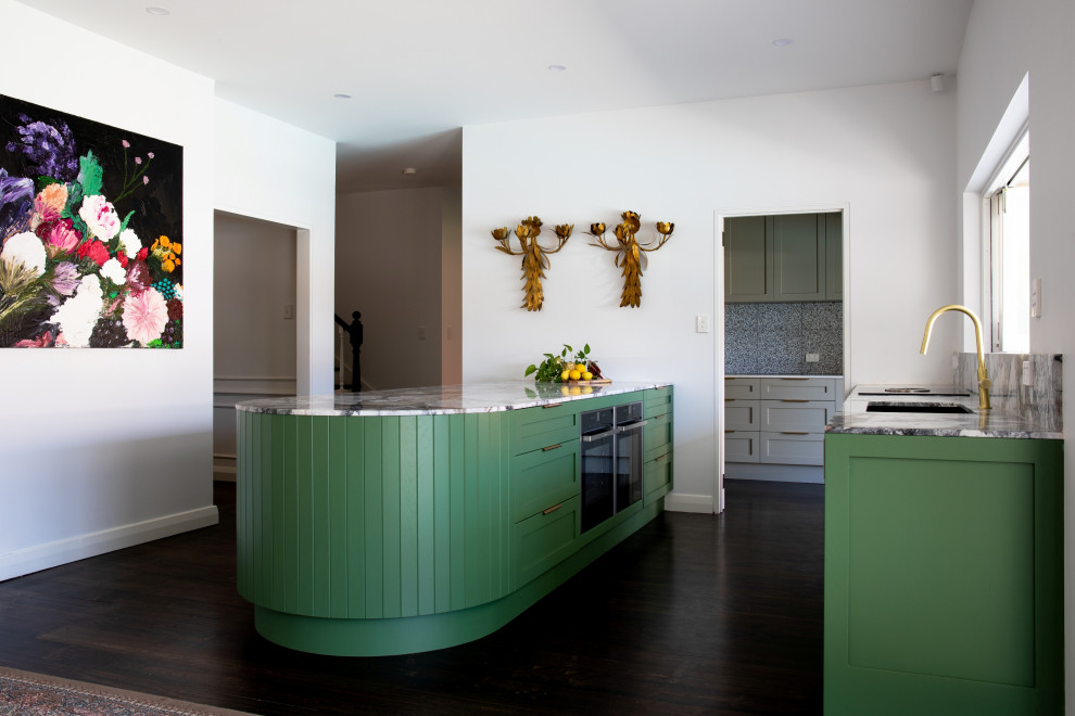 Photo of a large contemporary galley kitchen in Adelaide with an undermount sink, shaker cabinets, green cabinets, marble benchtops, multi-coloured splashback, marble splashback, black appliances, brown floor, multi-coloured benchtop, dark hardwood floors and a peninsula.