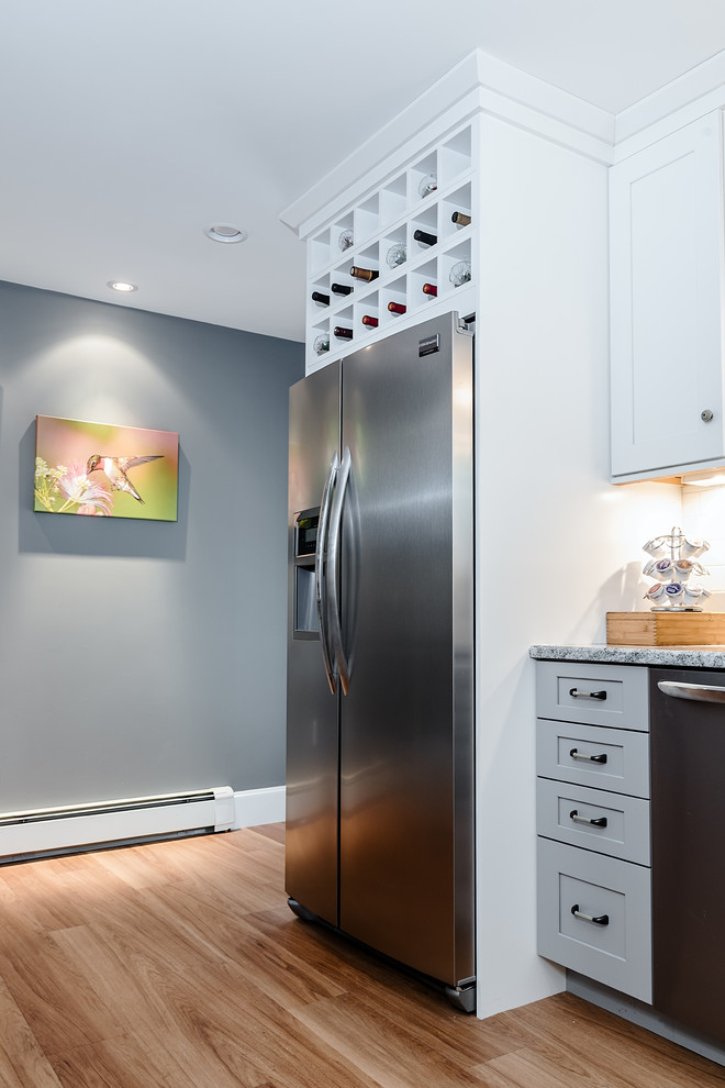 Design ideas for a mid-sized contemporary u-shaped kitchen in Providence with a farmhouse sink, shaker cabinets, grey cabinets, granite benchtops, white splashback, subway tile splashback, stainless steel appliances, light hardwood floors and no island.