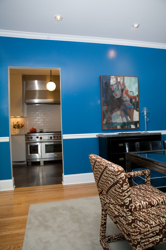 This is an example of a large contemporary separate dining room in Chicago with blue walls, medium hardwood floors and no fireplace.