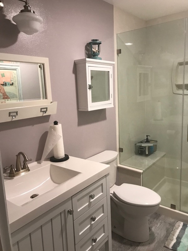 Design ideas for a mid-sized beach style 3/4 bathroom in Orange County with recessed-panel cabinets, white cabinets, an alcove shower, a one-piece toilet, purple walls, plywood floors, a drop-in sink, quartzite benchtops, grey floor, a hinged shower door, yellow benchtops, a shower seat, a single vanity and a freestanding vanity.