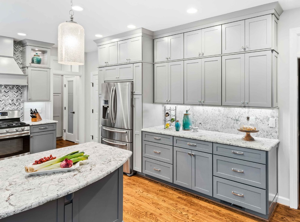 Inspiration for a mid-sized transitional u-shaped medium tone wood floor and brown floor eat-in kitchen remodel in Raleigh with a single-bowl sink, shaker cabinets, gray cabinets, granite countertops, white backsplash, porcelain backsplash, stainless steel appliances, a peninsula and white countertops
