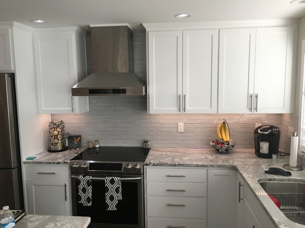 Eat-in kitchen - large transitional l-shaped dark wood floor and brown floor eat-in kitchen idea in Seattle with a single-bowl sink, shaker cabinets, white cabinets, quartz countertops, glass tile backsplash, stainless steel appliances and an island