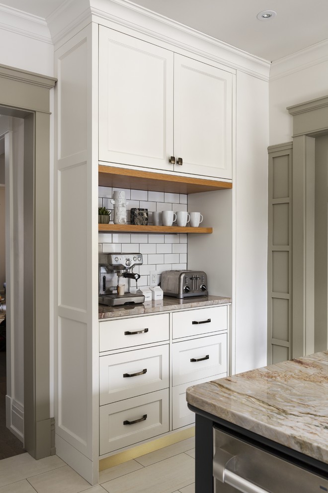 Enclosed kitchen - mid-sized transitional l-shaped porcelain tile enclosed kitchen idea in Toronto with an undermount sink, beaded inset cabinets, black cabinets, quartzite countertops, white backsplash, subway tile backsplash, stainless steel appliances and an island