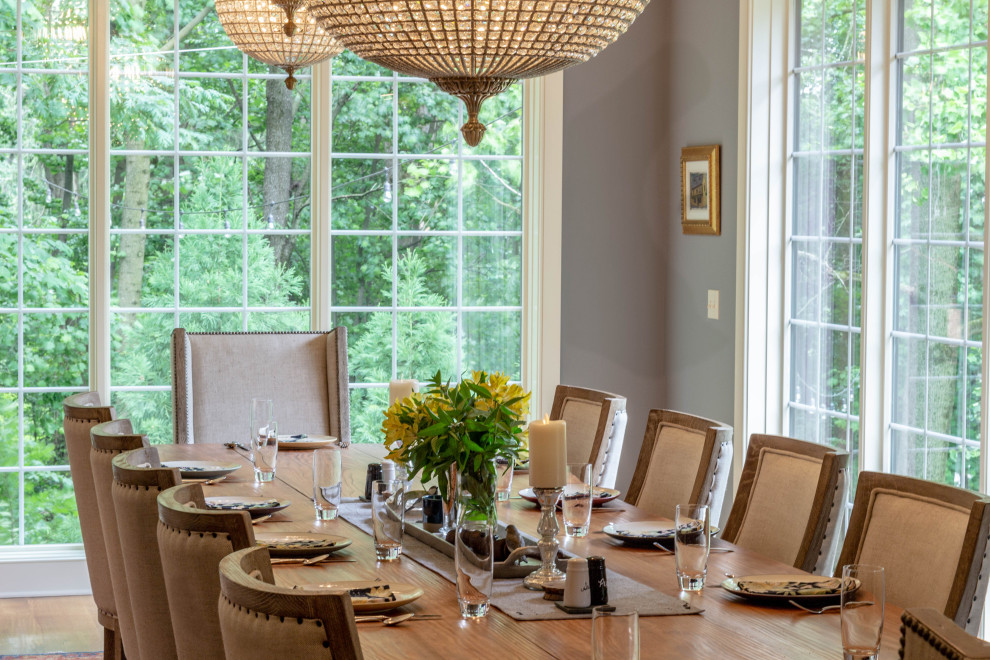 Example of a large transitional medium tone wood floor, brown floor and exposed beam enclosed dining room design with gray walls