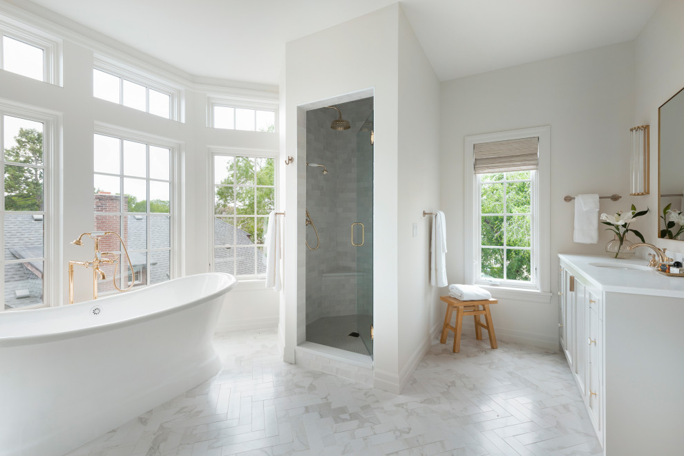 Design ideas for an expansive transitional master bathroom in Minneapolis with recessed-panel cabinets, a freestanding tub, an alcove shower, a hinged shower door, white benchtops, a double vanity, a built-in vanity, beige cabinets, a two-piece toilet, beige walls, porcelain floors, an undermount sink, marble benchtops and white floor.