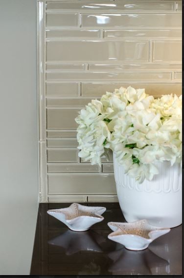 Home design - contemporary home design idea in Vancouver with recessed-panel cabinets, white cabinets, quartzite countertops, beige backsplash, glass tile backsplash, stainless steel appliances and an island