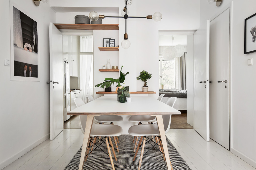 Design ideas for a mid-sized scandinavian dining room in Stockholm with white walls and painted wood floors.