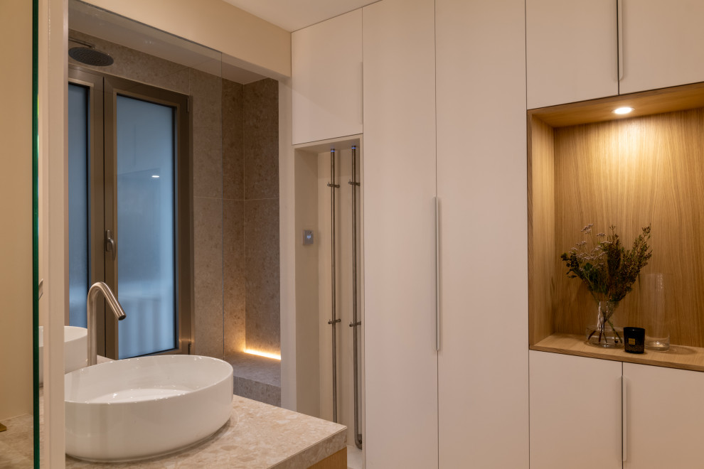 This is an example of a medium sized contemporary shower room bathroom in Paris with beaded cabinets, brown cabinets, a built-in shower, a two-piece toilet, beige tiles, ceramic tiles, beige walls, a built-in sink, tiled worktops, an open shower, beige worktops, a shower bench, double sinks and a freestanding vanity unit.