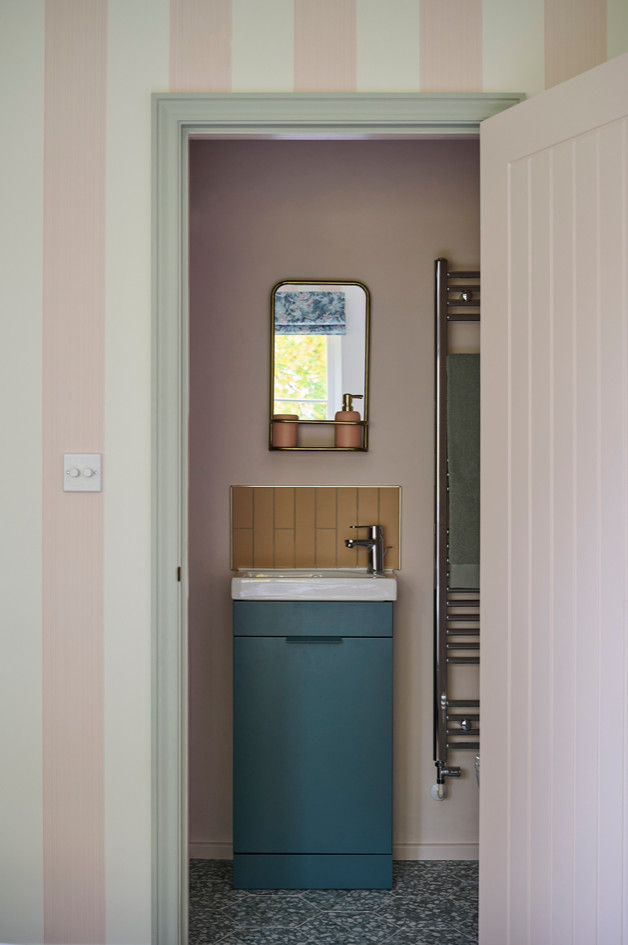 Small scandinavian bathroom in Other with flat-panel cabinets, green cabinets, an alcove shower, a two-piece toilet, pink tile, pink walls, ceramic floors, an integrated sink, green floor, a hinged shower door, a single vanity and a freestanding vanity.