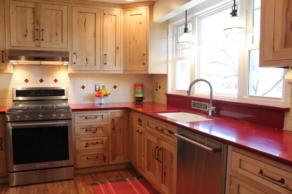 Mid-sized mountain style l-shaped laminate floor enclosed kitchen photo in Philadelphia with a double-bowl sink, shaker cabinets, light wood cabinets, quartz countertops, beige backsplash, ceramic backsplash, stainless steel appliances and no island