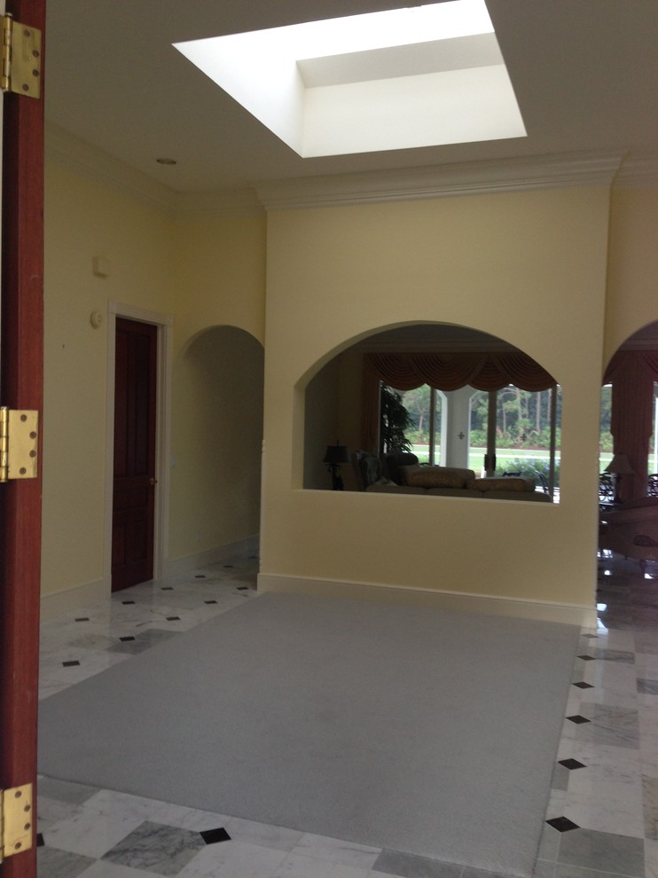 Small traditional foyer in Miami with beige walls, a single front door, a dark wood front door and marble floors.