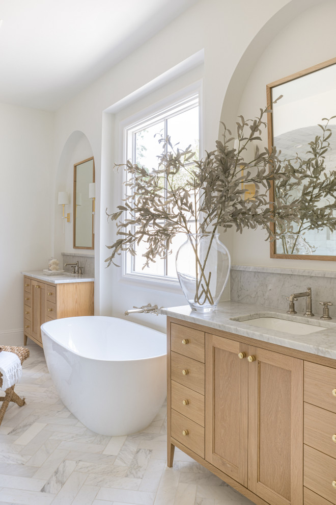 Cottage master gray tile and stone slab white floor and double-sink freestanding bathtub photo in Dallas with shaker cabinets, light wood cabinets, beige walls, an undermount sink, gray countertops and a freestanding vanity