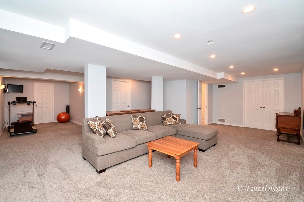 This is an example of a mid-sized traditional look-out basement in Chicago with grey walls, carpet and beige floor.