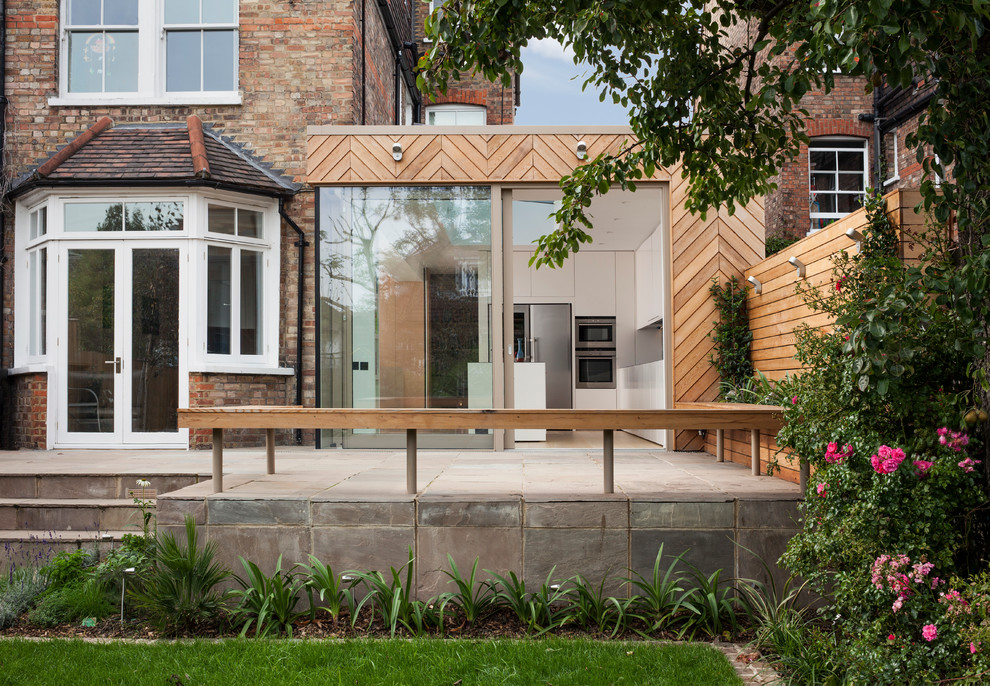 Large contemporary three-storey brown exterior in London with wood siding and a flat roof.