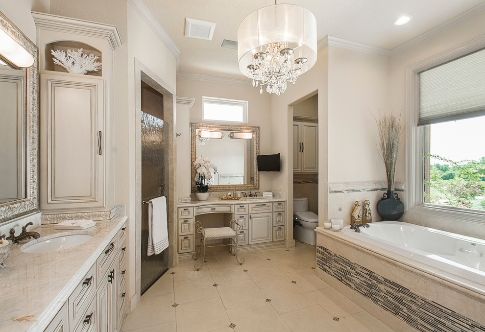Inspiration for a mid-sized transitional master bathroom in Dallas with furniture-like cabinets, white cabinets, a drop-in tub, a curbless shower, a bidet, white tile, limestone, white walls, limestone floors, an undermount sink, marble benchtops, white floor and a hinged shower door.