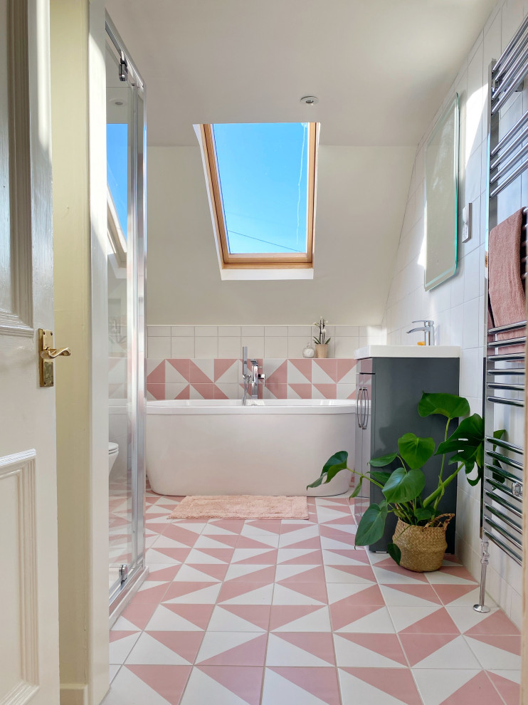 На фото: детская ванная комната среднего размера в современном стиле с плоскими фасадами, серыми фасадами, отдельно стоящей ванной, душем без бортиков, белой плиткой, керамической плиткой, полом из керамической плитки, розовым полом, душем с распашными дверями, нишей, тумбой под одну раковину и встроенной тумбой
