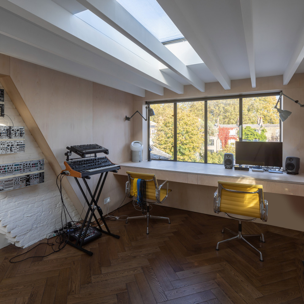 Cette image montre un bureau bohème en bois de taille moyenne et de type studio avec un sol en bois brun, un bureau intégré, un sol marron et poutres apparentes.