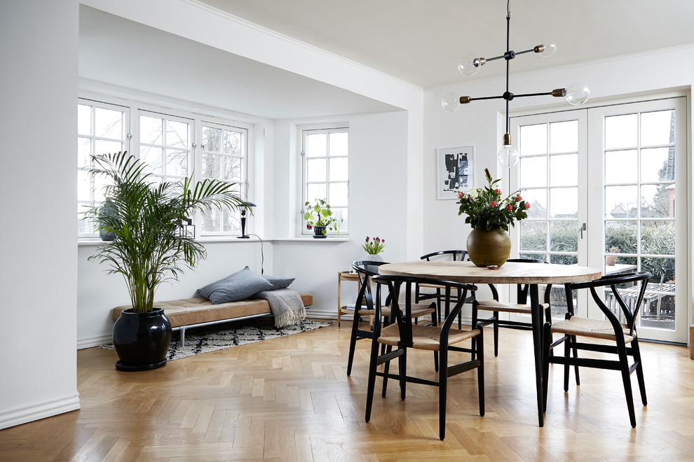 Mid-sized scandinavian dining room in Aarhus with beige floor, white walls and light hardwood floors.