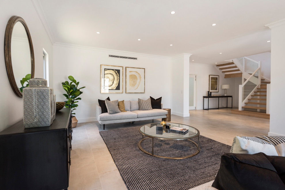 Large contemporary open concept family room in Sydney with white walls, light hardwood floors, a standard fireplace and a wall-mounted tv.