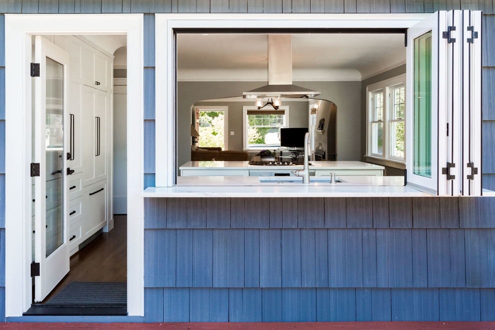 Inspiration for a mid-sized transitional l-shaped dark wood floor and brown floor open concept kitchen remodel in Seattle with an undermount sink, shaker cabinets, white cabinets, quartz countertops, white backsplash, porcelain backsplash, stainless steel appliances and an island
