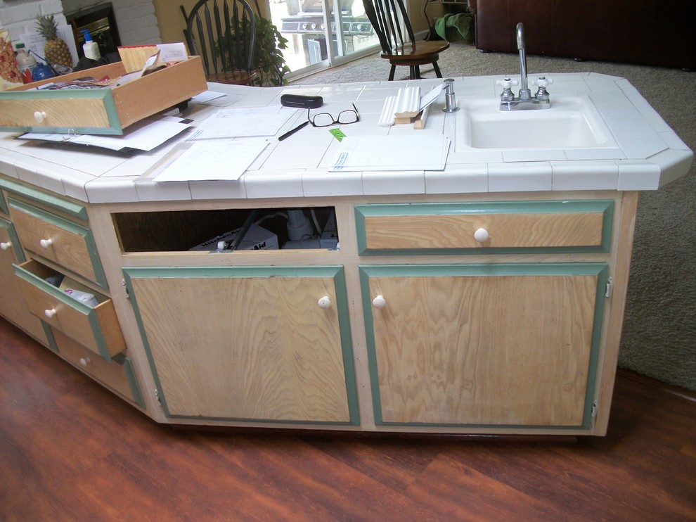 Eat-in kitchen - mid-sized transitional u-shaped dark wood floor eat-in kitchen idea in Sacramento with raised-panel cabinets, white cabinets, tile countertops, white backsplash, ceramic backsplash, black appliances, a peninsula and a drop-in sink