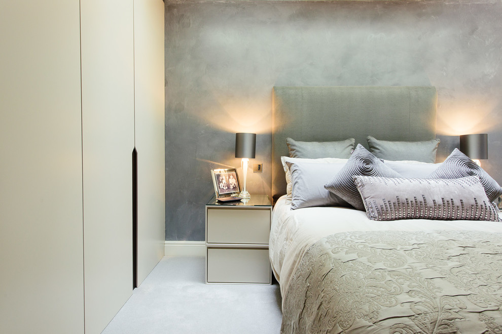 This is an example of a large transitional bedroom in London with grey walls and carpet.