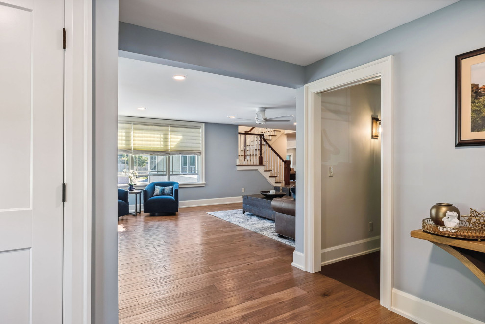 This is an example of a mid-sized traditional foyer in Columbus with blue walls, medium hardwood floors, a single front door, a dark wood front door and brown floor.