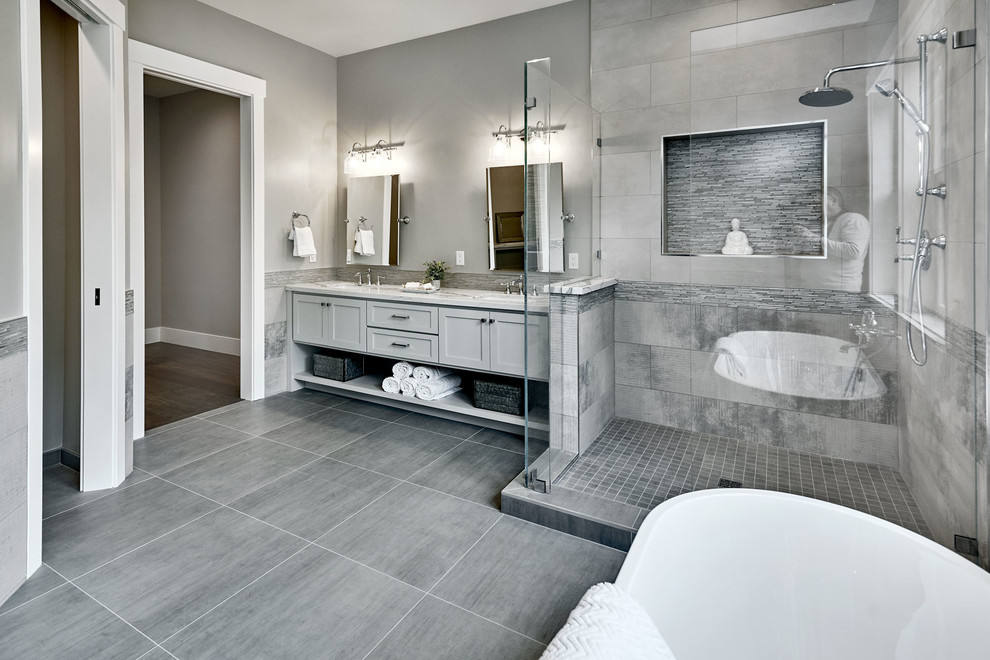 Expansive contemporary master bathroom in San Francisco with flat-panel cabinets, grey cabinets, a freestanding tub, an open shower, a one-piece toilet, gray tile, porcelain tile, grey walls, porcelain floors, an undermount sink, engineered quartz benchtops, grey floor, a hinged shower door and white benchtops.