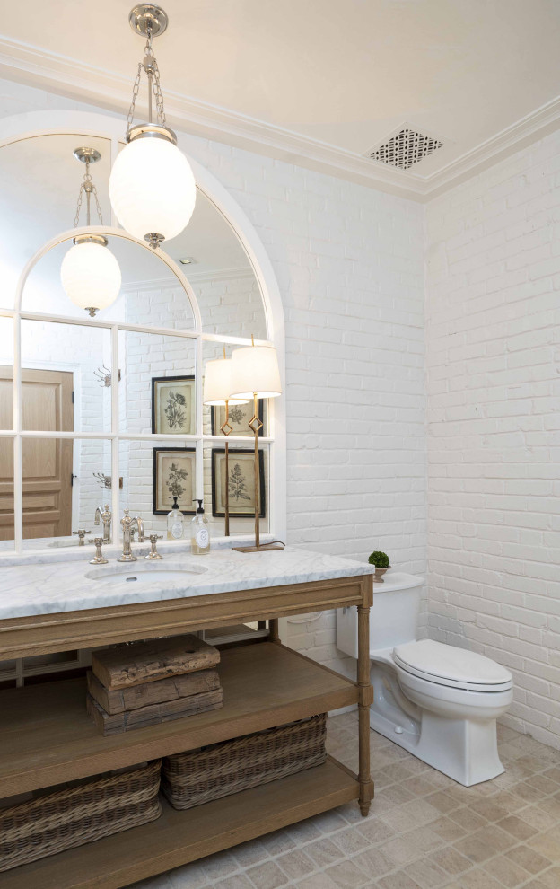 Bathroom - french country master beige floor, single-sink and brick wall bathroom idea in Baltimore with distressed cabinets, a two-piece toilet, white walls, an undermount sink, granite countertops, multicolored countertops and a freestanding vanity