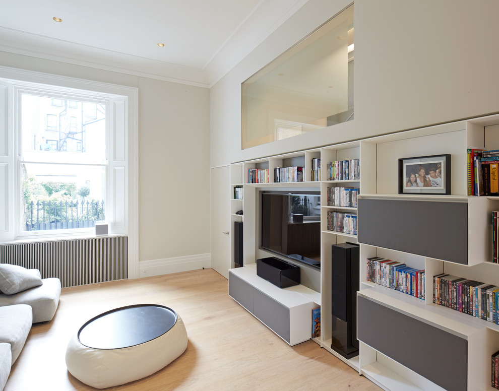 Design ideas for a mid-sized contemporary enclosed home theatre in London with grey walls, light hardwood floors and a built-in media wall.