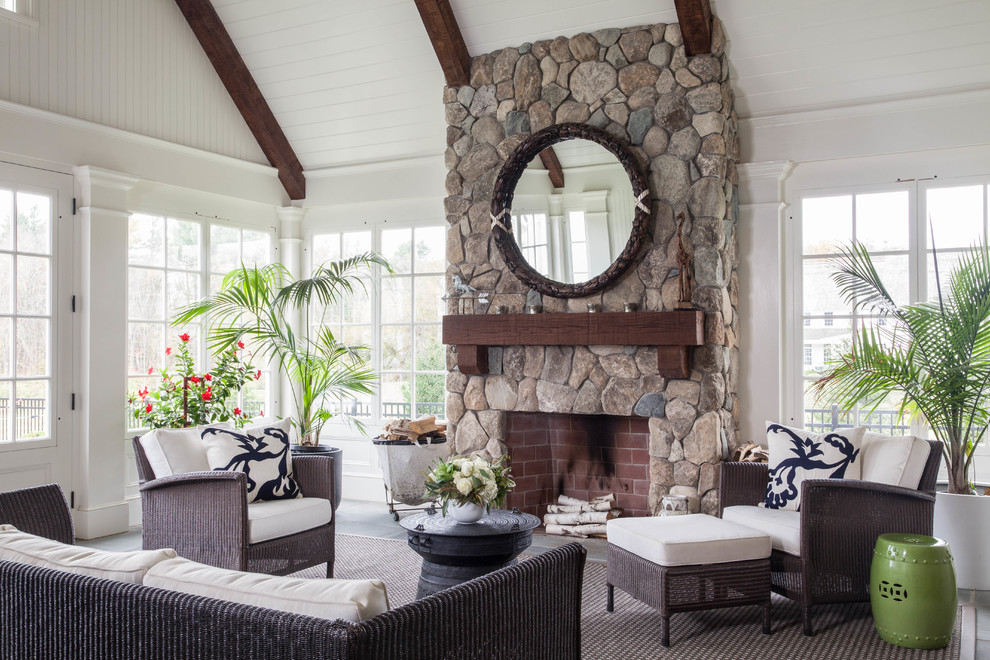This is an example of a large traditional sunroom in Boston with a standard fireplace, a stone fireplace surround, a standard ceiling and grey floor.