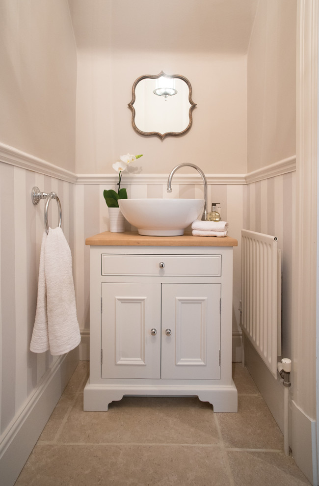 This is an example of a traditional powder room in Surrey with beige benchtops.