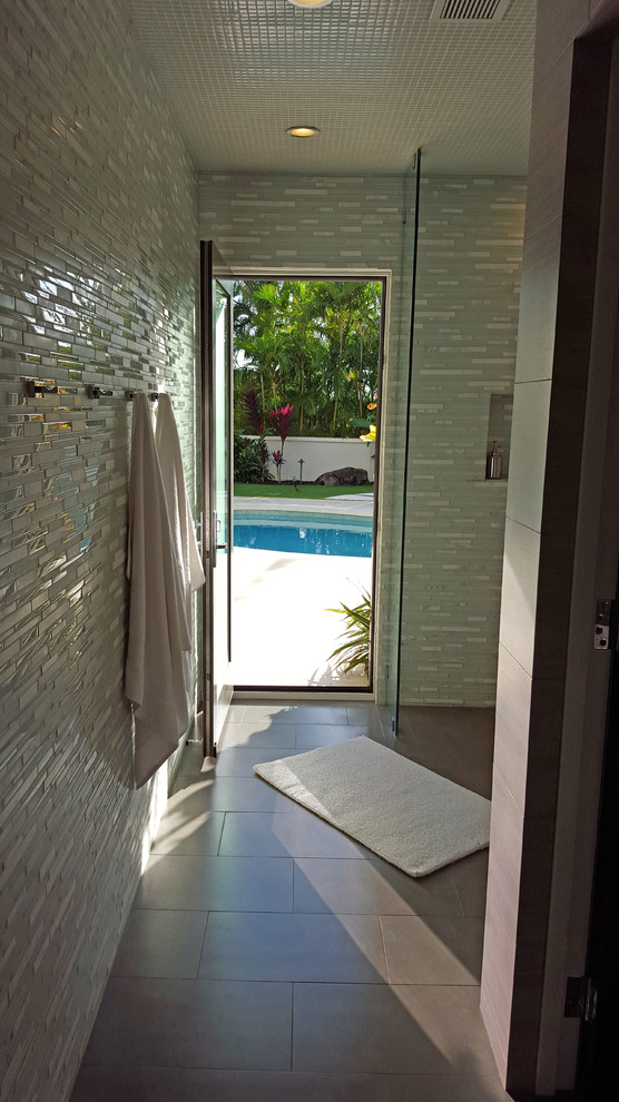 This is an example of a mid-sized tropical 3/4 bathroom in Other with a corner shower, blue tile, white tile, multi-coloured walls, porcelain floors, matchstick tile, a vessel sink and quartzite benchtops.