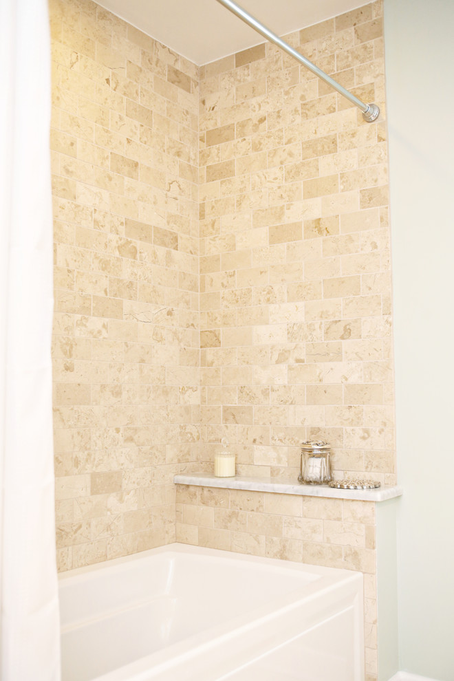 Inspiration for a transitional bathroom in Portland with an undermount sink, recessed-panel cabinets, white cabinets, marble benchtops, an alcove tub, a shower/bathtub combo, a one-piece toilet, beige tile, stone tile and travertine floors.