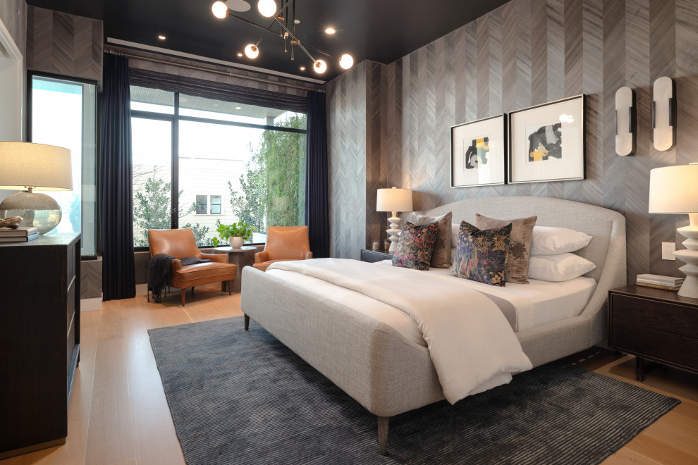 Foto di una camera da letto design con pareti grigie, pavimento in legno massello medio, pavimento marrone e carta da parati