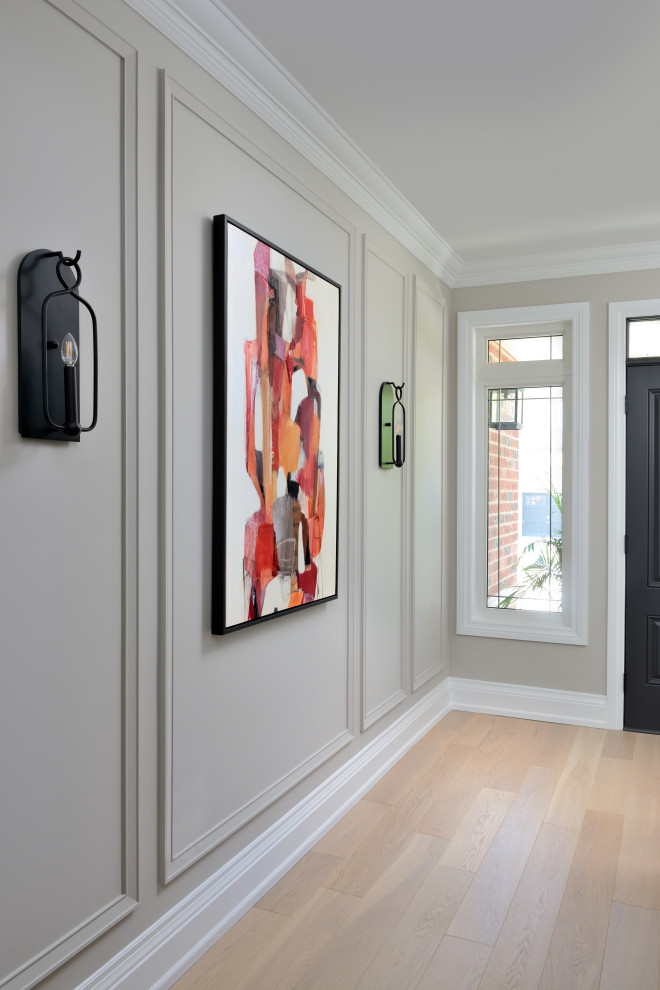 Источник вдохновения для домашнего уюта: узкая прихожая среднего размера в стиле неоклассика (современная классика) с паркетным полом среднего тона, одностворчатой входной дверью, черной входной дверью, серыми стенами и бежевым полом