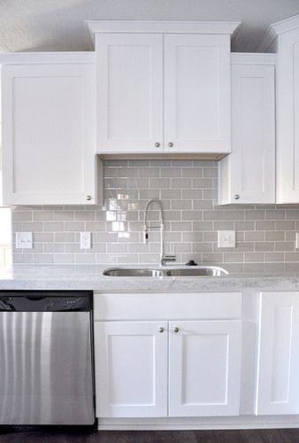 Enclosed kitchen - large transitional l-shaped concrete floor and gray floor enclosed kitchen idea in Orange County with an undermount sink, shaker cabinets, white cabinets, solid surface countertops, gray backsplash, stainless steel appliances, no island and ceramic backsplash