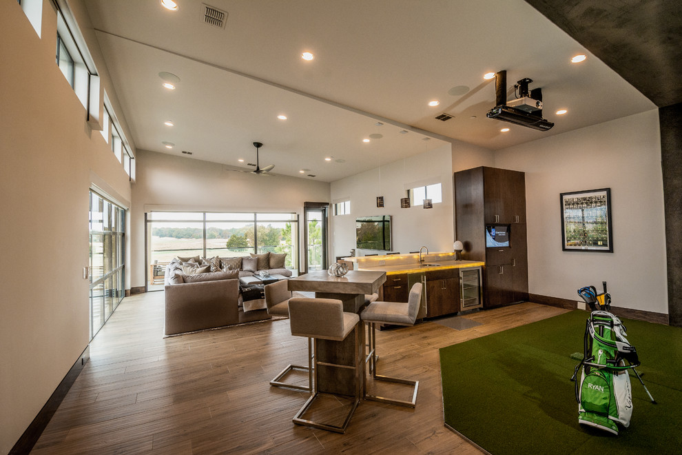 This is an example of an expansive contemporary open concept family room in Orange County with a game room, beige walls, porcelain floors, a wall-mounted tv and brown floor.