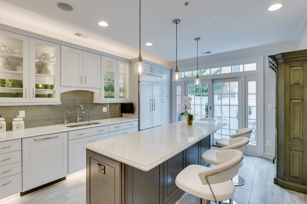 Inspiration for a large transitional l-shaped kitchen in DC Metro with an undermount sink, raised-panel cabinets, quartz benchtops, green splashback, subway tile splashback and with island.