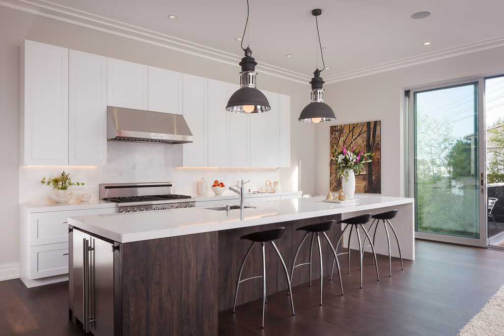 Inspiration for a contemporary galley kitchen in Seattle with an undermount sink, shaker cabinets, white cabinets, white splashback, stainless steel appliances, dark hardwood floors and with island.