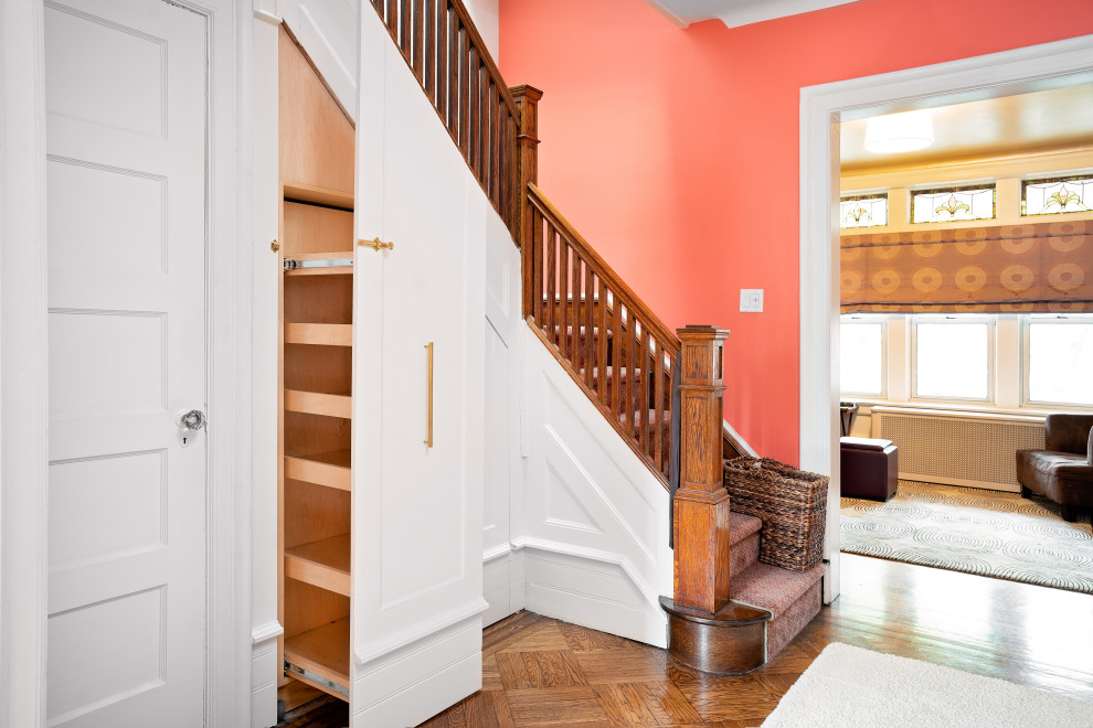 Small eclectic carpeted l-shaped staircase in New York with carpet risers and wood railing.