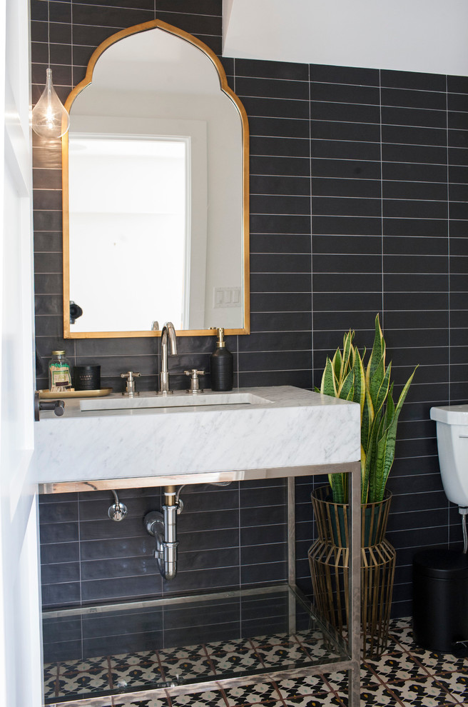This is an example of a small contemporary powder room in Orange County with a one-piece toilet, black tile, cement tile, black walls, cement tiles, a pedestal sink, marble benchtops and multi-coloured floor.